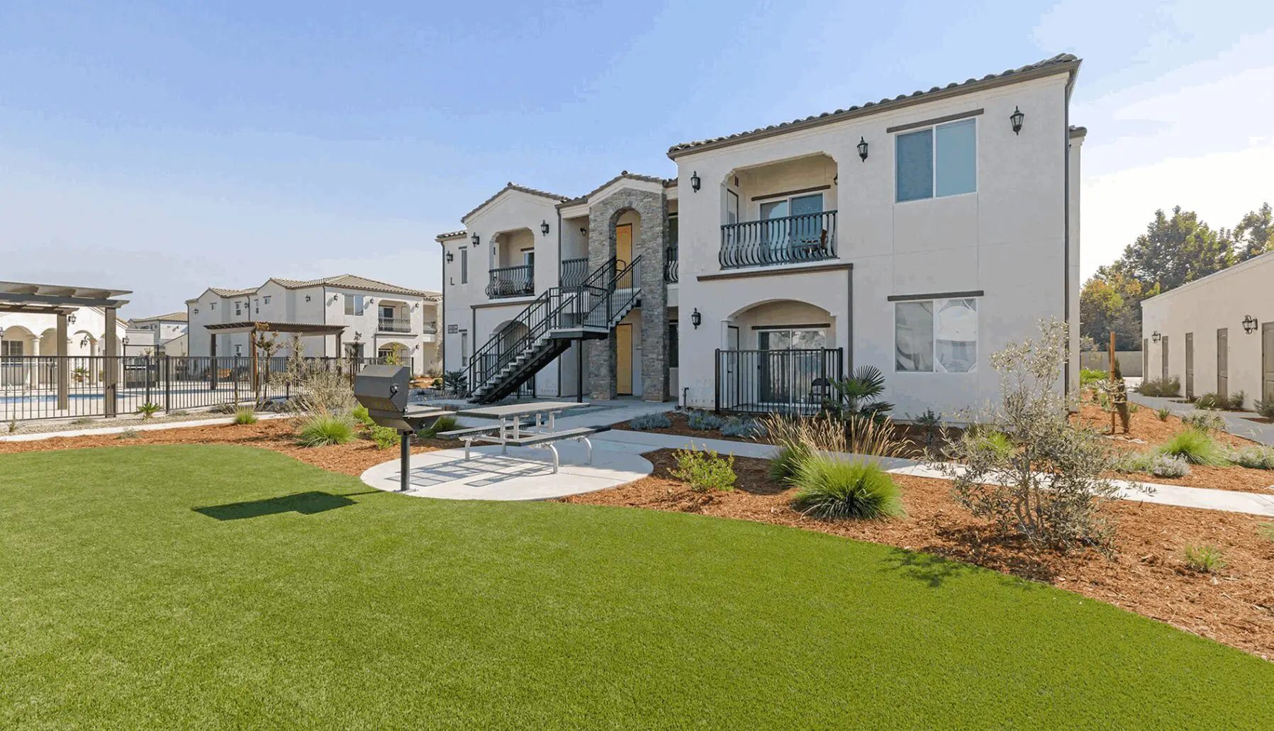 A large lawn area with grass and buildings.
