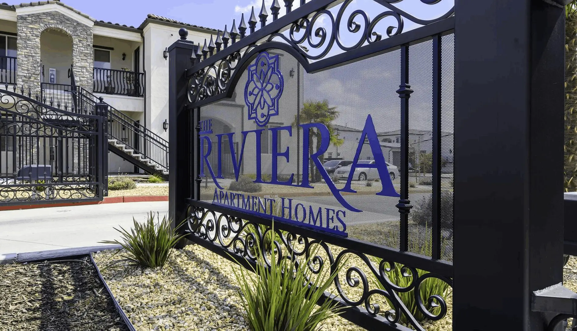 A sign for the riviera apartments in front of a building.