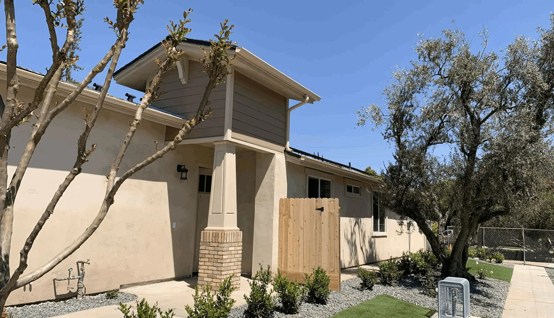 A house with a fence and trees in front of it