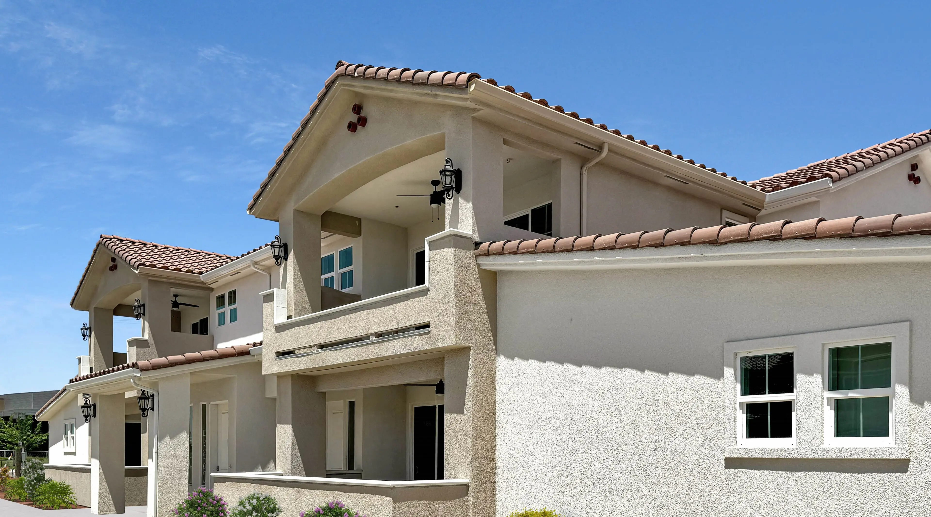 A large white building with a balcony and two windows.