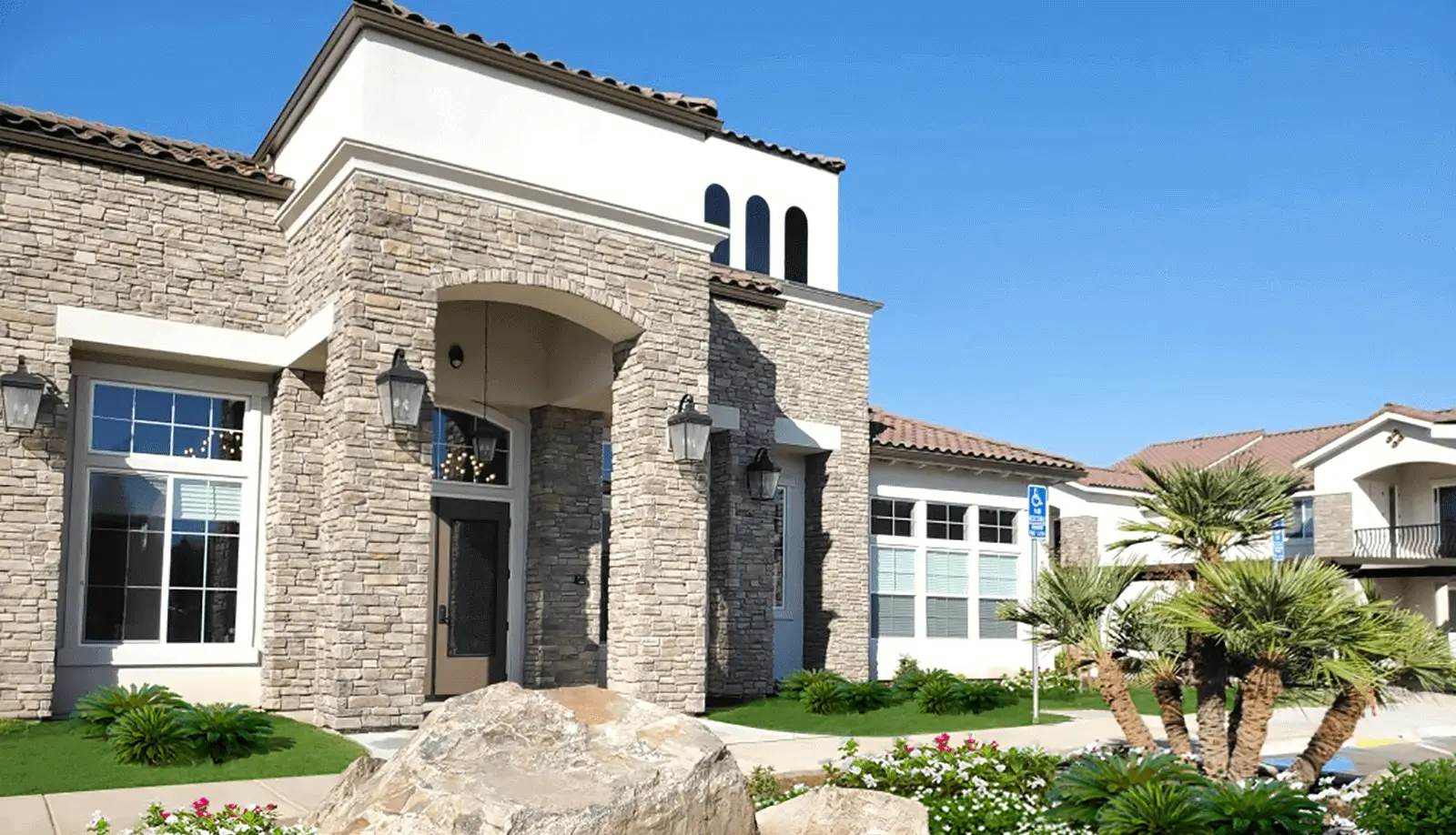 Stone veneer clubhouse with arched entry and lanterns